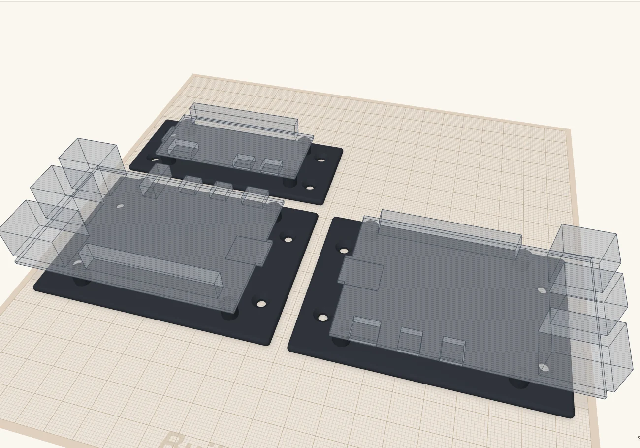 Three mounting plates on the build plate: a Pi Zero 2 W mount at the back, and Pi 4 and Pi 5 mounts in front, each with a see-through outline of the board and its ports sitting on its standoffs.