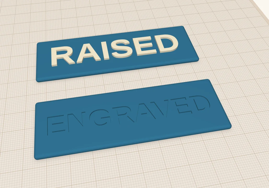 Two blue plates: on one, the word RAISED stands up in cream letters; on the other, the word ENGRAVED is cut into the surface.