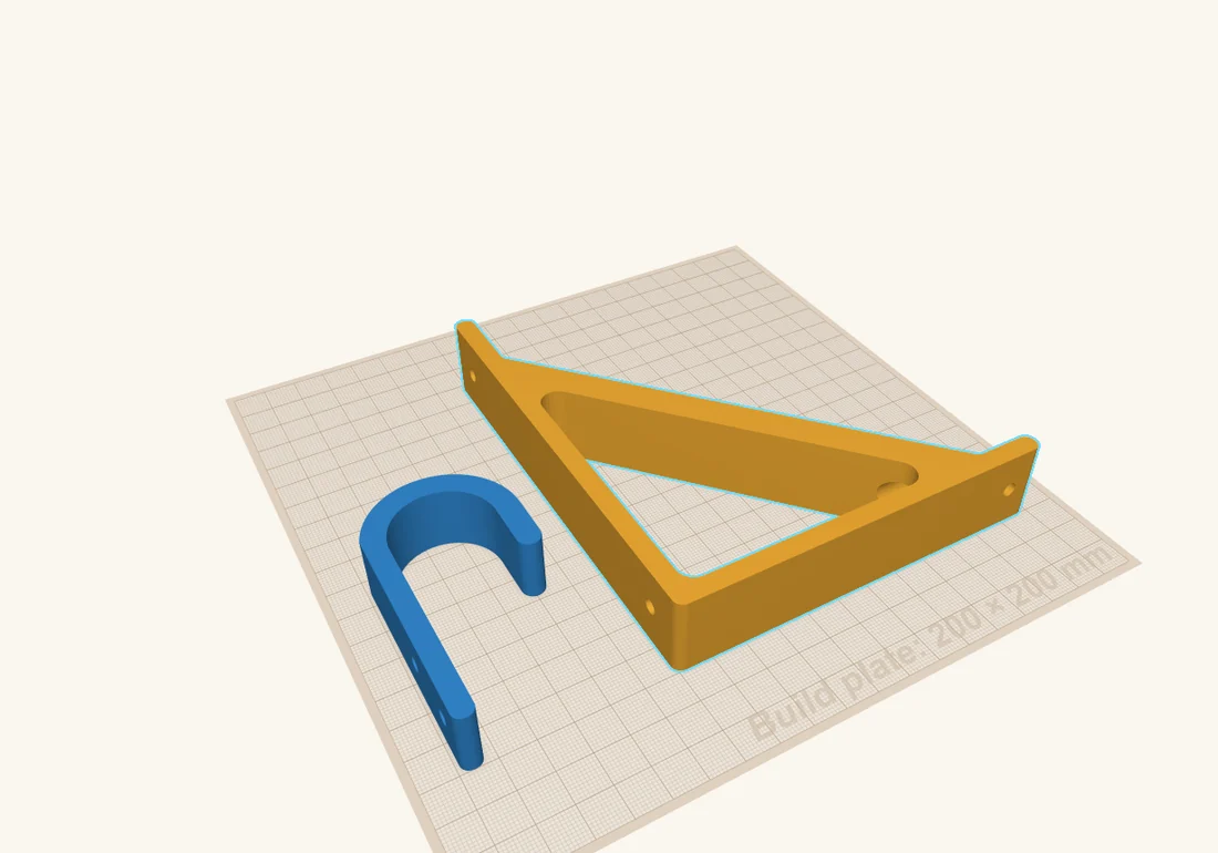 The hook and the bracket both lying on their sides on the build plate, ready to print.